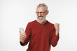 © InsideCreativeHouse - Grey-haired mature man celebrating victory win online casino bet on sport, winning money on cellphone smart phone isolated in white background. Sale offer discount