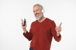© InsideCreativeHouse - Active senior mature middle-aged man listening to the music song playlist e-book podcast in headphones on cellphone in mobile application online isolated in white background