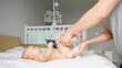 © lenblr - Young green father watches instructional video how to change diaper for baby daughter lying on bed via laptop at home. Hygiene care of newborn child