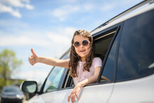 Young Girl Looking Out Of Car Window Smiling