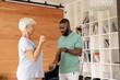 African american male physiotherapist helping caucasian senior woman to do exercise with dumbbells
