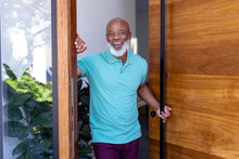 Portrait Of Cheerful African American Senior Man Welcoming While Standing At Doorway In Nursing Home
