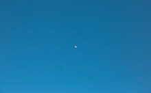 The Moon Is Visible In The Blue Sky During The Day