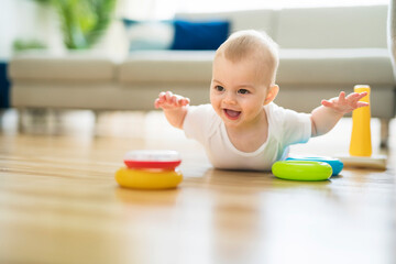 Cute 8 month baby laying on floor, playing with toys