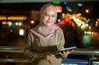 © tonefotografia - A young Muslim Businesswoman is using tablet computer in modern City at night , Business technology lifestyle concept