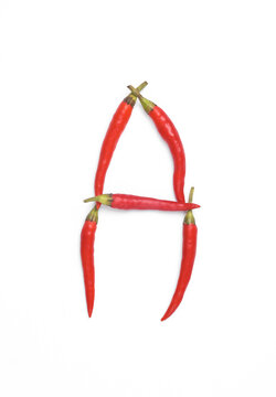Letter A made from red chilli peppers isolated on white background