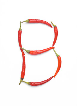 Letter B made from red chilli peppers isolated on white background