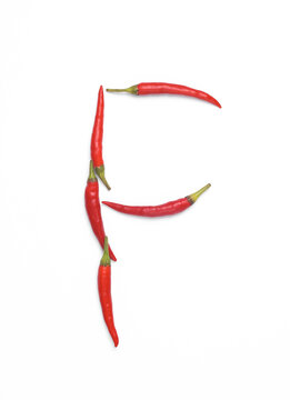 Letter F made from red chilli peppers isolated on white background