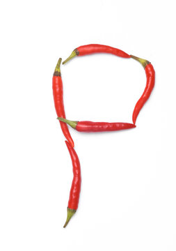 Letter P made from red chilli peppers isolated on white background