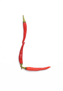 Letter L made from red chilli peppers isolated on white background