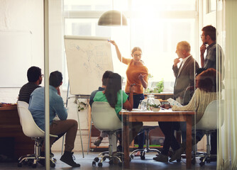 All hands are on deck for this meeting. Shot of a group of coworkers in a boardroom meeting.