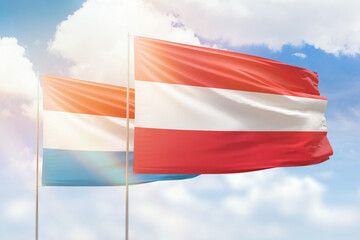 Sunny blue sky and flags of austria and luxembourg