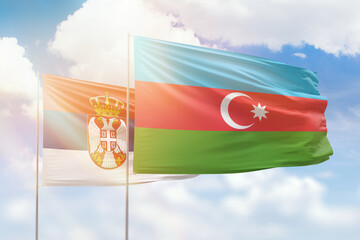 Sunny blue sky and flags of azerbaijan and serbia