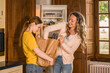 Happy woman taking food from the package while preparing to the cooking with her teen daughter