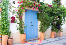 Old Wooden Colorful Door With Flowers And A Rainbow, Cordoba, Spain.