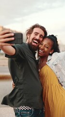 Wall Mural - VERTICAL VIDEO: Closeup of smiling interracial couple taking a selfie on fountain background. Close-up, man and woman video chatting using a mobile phone