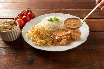 Chicken stroganoff accompanied with rice, salad and potato straw.