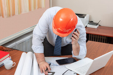 A civil engineer in his office is working on an industrial building construction project