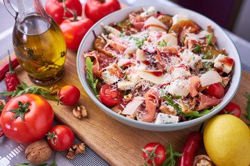 Wall Mural - Salad with jamon or prosciutto, pears, tomatoes and arugula on wooden board