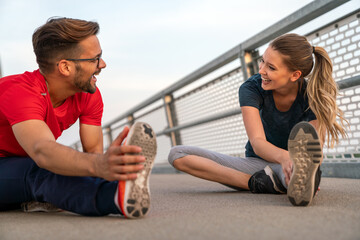 Romantic couple doing sport together on the street. Having fun after morning run