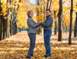 © soleg - portrait of a romantic couple in an autumn city park, a man and a woman walking and posing against the background of yellow maple leaves, a bright sunny day