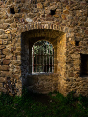  imagen detalle ventana en una muralla de piedra con una verja de hierro