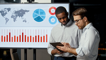 Poster - Two businessmen discussing new startup strategies using computer technology in office