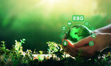 Fototapeta Kawa jest smaczna - Environment social and governance in sustainable and ethical business.Hand holding crystal globe with network connection and ESG icons. Using technology of renewable resource to reduce pollution