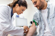 © Graphicroyalty - Friendly hospital phlebotomist collecting blood sample from patient in lab. Preparation for blood test by female doctor medical uniform on the table in white bright room