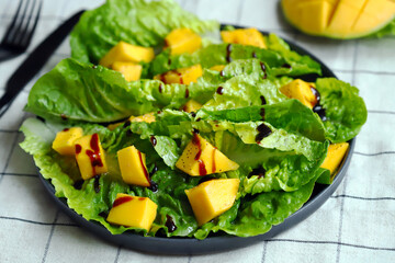 Wall Mural - Healthy bright salad with mango and green romaine leaves. Diet food.