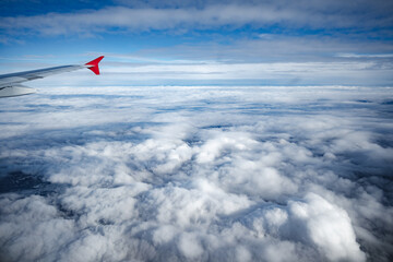 Wall Mural - aircraft wing above beautiful clouds and blue sky