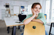 © contrastwerkstatt - Happy young business woman leans on her desk chair and looks to the side laughing