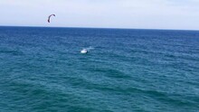A Spanish Kite Surfer Riding The Waves On The Coast Outside Nerja In Andalusia. A Fun Sports Activity In Spain. A Popular Water Sport On The Coastline Outside Nerja In The Costa Del Sol.
