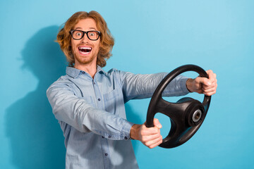 Sticker - Photo of positive overjoyed man hands hold wheel drive fast speed isolated on blue color background