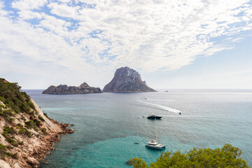 Panoramic view from the southern edge of Cola d'Hort bay to 2 small cliff islands Es Vedra and Es Vedranell, Ibiza, Balearic Islands, Spain