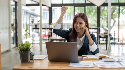 Portrait of happy young business asian woman celebrating success with arms up. positive expression, success in business concept.