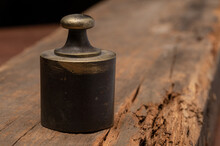 Antique Brass Scale Weight On Rustic Wood Texture, Labeled Libra 1/4