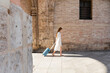 © LIGHTFIELD STUDIOS - side view of redhead woman walking with baggage and using smartphone on european street.