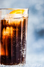 Close-up Of A Cola Drink With Ice Cubes And A Slice Of Fresh Orange