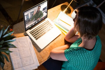 Poster - African american businessman waving on video call with caucasian female colleague sitting at desk