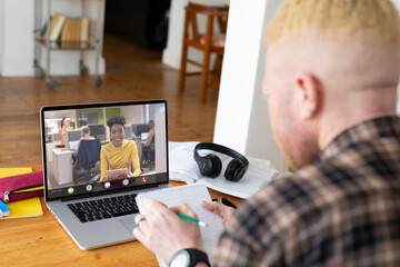 Canvas Print - African american businesswoman during video call with african american albino male colleague