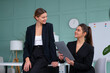 © Andrii - Young women leaders are checking financial statements from paper documents. Two female confident business worker dressed black suit in office checking financial document