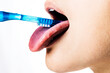 canvas print picture - Close Up Mund, weibliches Model putzt sich die Zunge mit einem Zungenreiniger, seitlich