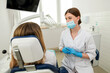© Tania - A beautiful female dentist is talking to a patient while sitting in a chair.