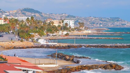 Wall Mural - Mediterranean sea coast in Sanremo, Italy. Beach, residential buildings in the distance