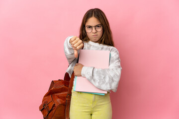 Wall Mural - Student little girl over isolated pink background showing thumb down with negative expression