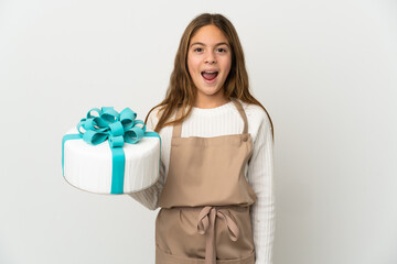 Wall Mural - Little girl holding a big cake over isolated white background with surprise facial expression