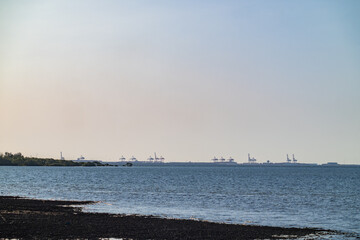 Wall Mural - Line of container cranes at Port of Brisbane on distant horizon