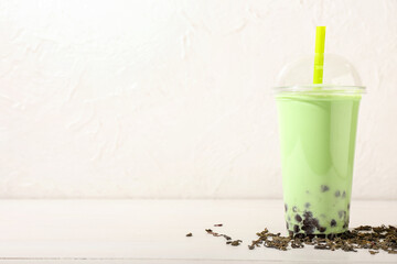 Plastic cup of tasty bubble tea on light background