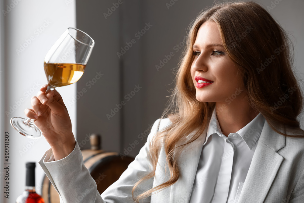 Beautiful young female sommelier tasting types of wine